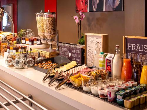 a buffet with food and drinks on a counter at ibis Cergy Pontoise Le Port in Cergy
