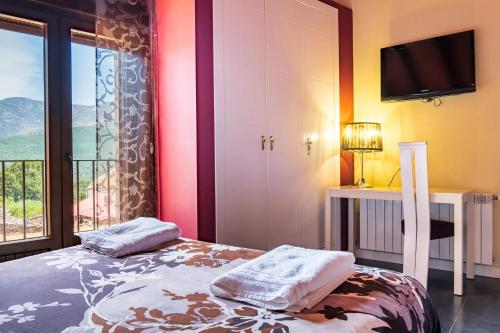 a bedroom with a bed and a large window at Baelo Claudia in Navalguijo