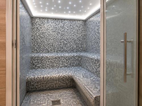 a bathroom with a shower with a bench in it at Le Petit Refuge in La Thuile