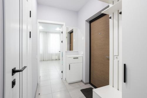 a bathroom with white walls and a white tile hallway at Nyvky Like Home - Fayna Town - apt 149 8 поверх, 1 буд in Kyiv