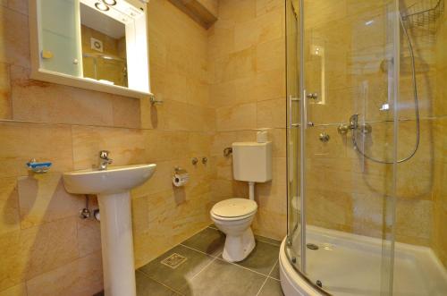a bathroom with a toilet and a sink and a shower at Villa Velzon Lux in Budva