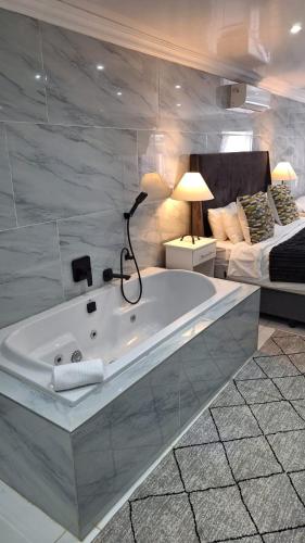 a bathroom with a bath tub in a bedroom at Lion Lodge in Bloemfontein