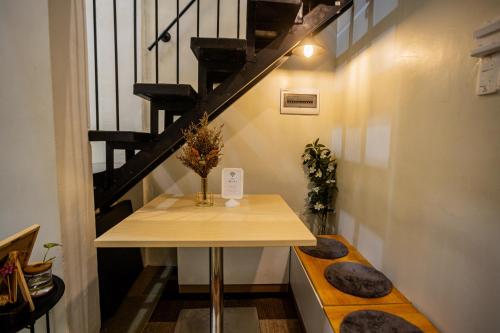 a small table in a room with a staircase at Staycation by ALCD in San Mateo