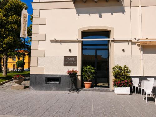 a building with chairs and flowers in front of it at Hotel Santuario Pompei in Pompei