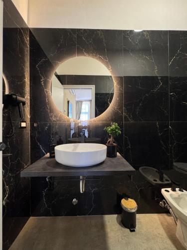 a bathroom with a large white tub and a mirror at Hotel Santuario Pompei in Pompei