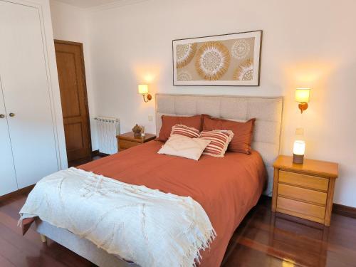 a bedroom with a large bed with two night stands at Casa com piscina para 10 pessoas - 5 min da praia Esposende in Esposende