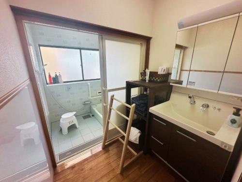 a bathroom with a sink and a shower and a toilet at MIYABI stay house in Tamana