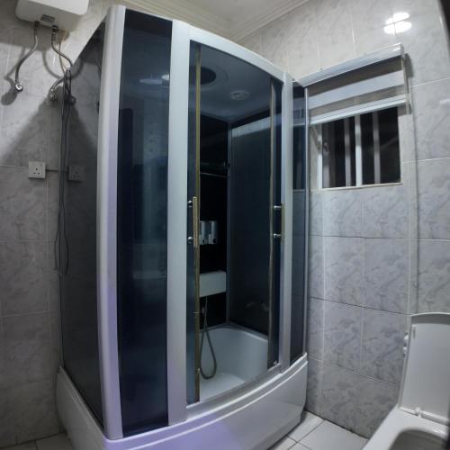 a shower with a glass door in a bathroom at Hotel 101 & Apartments in Karsana