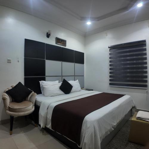 a bedroom with a large bed and a chair at Hotel 101 & Apartments in Karsana