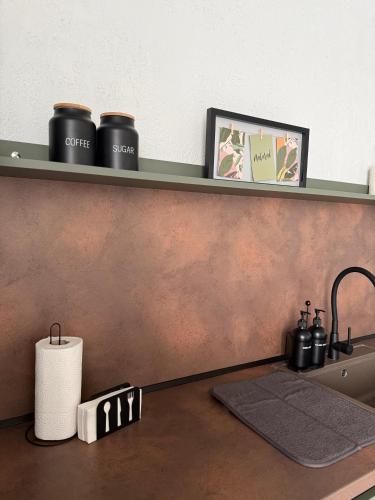 a kitchen counter with a sink and a shelf at Апартамент САМИ 102 in Dobrich