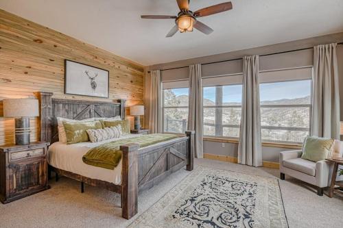 a bedroom with a bed and a chair and windows at Cutbow Lodge in South Fork