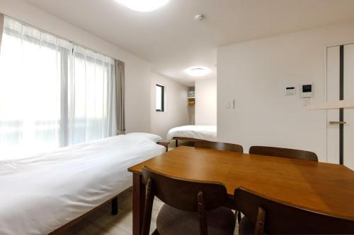 a room with a bed and a table and chairs at Anecis名楽町 in Nagoya