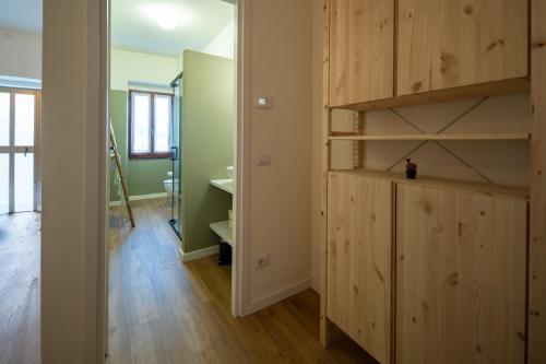 a room with a wooden book shelf and a hallway at Petra's House in Lenno
