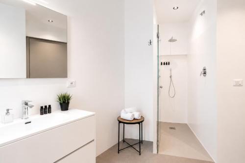 a white bathroom with a sink and a shower at Amare Suite & Apartments in Bellaria-Igea Marina