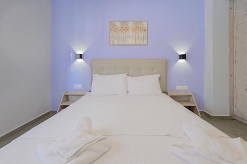 a bedroom with a white bed with two towels on it at Salty Sea View Apartments in Polychrono