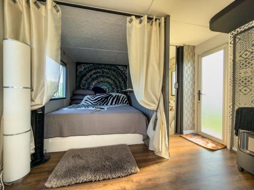 a bedroom with a bed with curtains and a rug at Holenderka nad Szelmentem in Jeleniewo