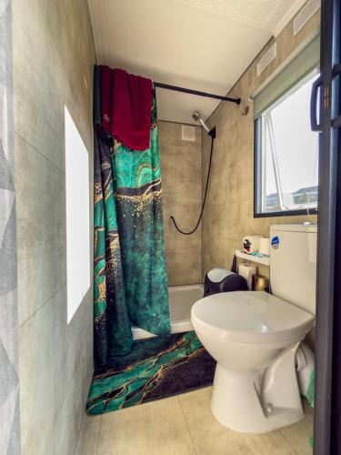 a bathroom with a toilet and a shower curtain at Holenderka nad Szelmentem in Jeleniewo