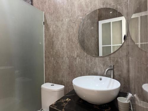a bathroom with a white sink and a mirror at Qiana House in Manggis