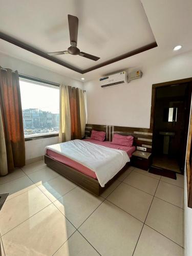 a bedroom with a bed and a large window at Laksh hotel,Proprietor Dilbag in Kurukshetra