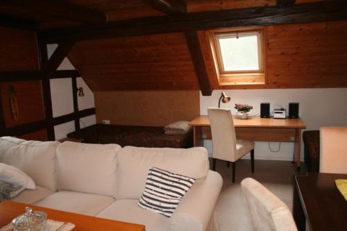 a living room with a white couch and a table at Ferienwohnungen Am Nussbaum in Saalfeld