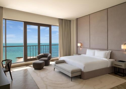 a bedroom with a bed and a view of the ocean at Ray Hotel by Cloud 7 in Kuwait