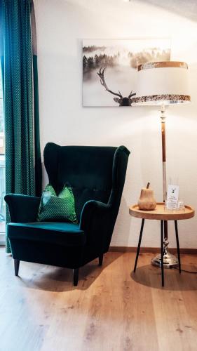 a living room with a green couch and a table at Vitalhotel Kaiserhof in Seefeld in Tirol