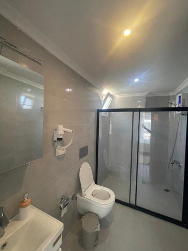a bathroom with a shower and a toilet and a sink at çam otel in Fethiye
