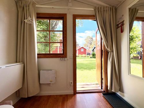 a room with a door open to a yard at B&B Parkgården Leksand in Leksand
