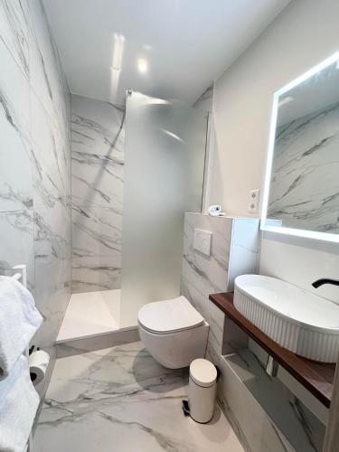 a white bathroom with a toilet and a sink at Hotel Casa Borghese in Senningerberg