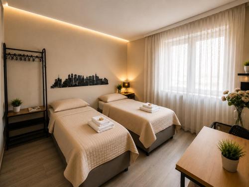 a hotel room with two beds and a table at Modern Living Apartment Hotel in Nuremberg