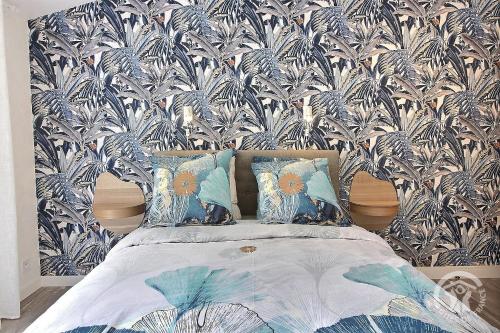 a bedroom with a bed with a blue and white wallpaper at L'impasse temps in Saint-Quay-Portrieux