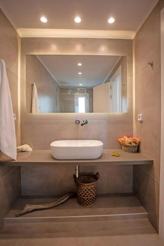 a bathroom with a sink and a mirror at Aegean View Suites Mykonos in Agios Stefanos