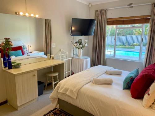 a hotel room with a bed and a desk and a desk at Beach House on Pachena in Plettenberg Bay