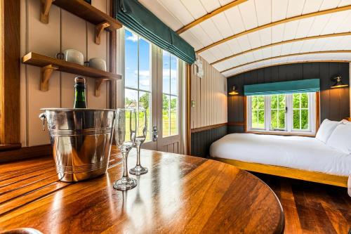 a room with a table with a bottle of wine on it at Berry Brook in Oakengrove Vineyard in Fawley