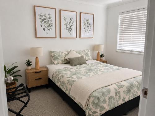 a bedroom with a bed and three pictures on the wall at Pandora Place in Lightning Ridge