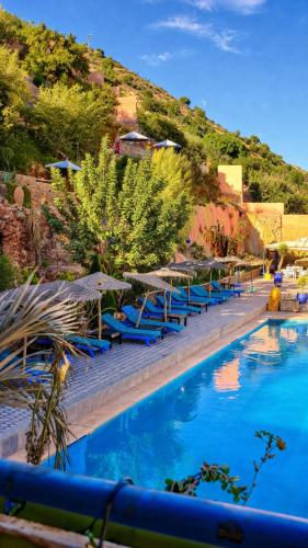 a row of blue lounge chairs next to a swimming pool at Auberge le Refuge in Agadir