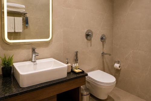 a bathroom with a sink and a toilet and a mirror at South Forest Wayanad By Bestinn Leisure in Sultan Bathery