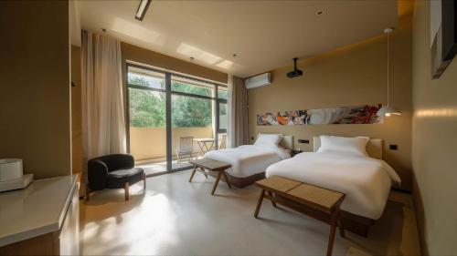 a hotel room with two beds and a window at Qinxiang Pavilion Hotel in Dunhuang