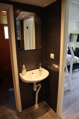 a bathroom with a sink and a mirror and a bed at Sjöstugan in Tyresö