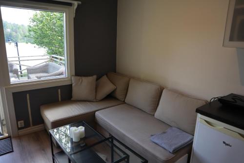 a living room with a couch and a window at Sjöstugan in Tyresö