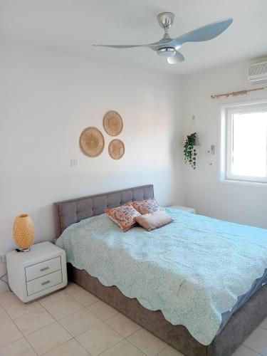 a bedroom with a bed and a ceiling fan at Empa Residence with private pool in Emba