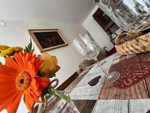ein Tisch mit einer Vase mit Blumen darauf in der Unterkunft Casa DeviDanza in Lago