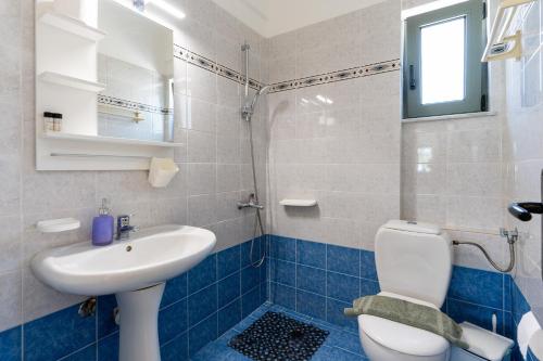 a bathroom with a white toilet and a sink at Kassiani Studios Olive Groove hotel in Plakias