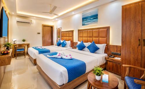 a hotel room with two beds and a table at South Forest Wayanad By Bestinn Leisure in Sultan Bathery
