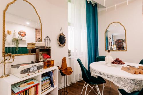 a dining room with a table and a mirror at Magiczny Salonik Harrego - Magical Old Town Apartment in Toruń