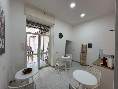 a room with two tables and chairs and a kitchen at B&B Napul'è in Naples