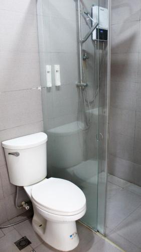 a bathroom with a toilet and a glass shower at Brisa Marina Beach Resort powered by Cocotel in Morong