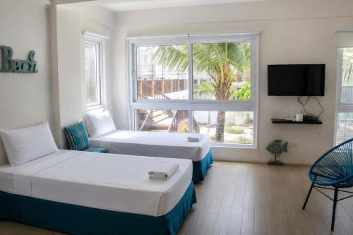 a hotel room with two beds and a window at Brisa Marina Beach Resort powered by Cocotel in Morong