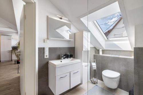 a bathroom with a toilet and a sink and a skylight at Ferienwohnung Jeannette in Balingen