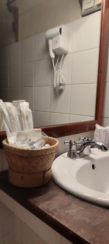 a bathroom counter with a sink and a basket of toiletries at Villa Saykham in Luang Prabang